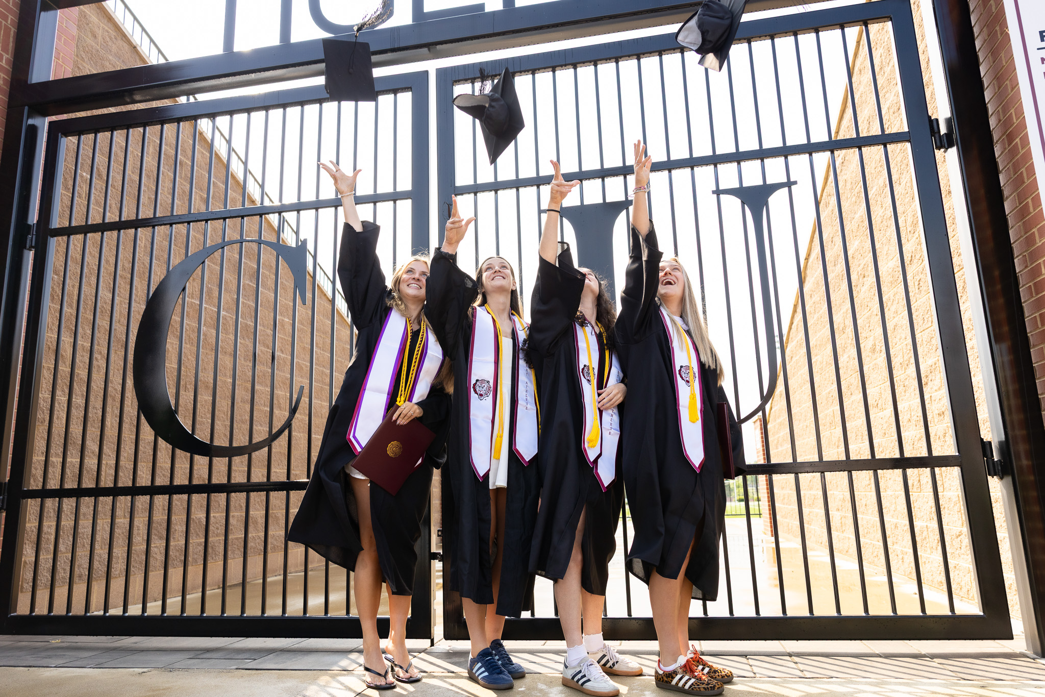 CU Women’s Soccer players toss their caps after their graduation. From left: Janne Rump, Milly Shakespeare, Bethin Boyle, Alex Glennie