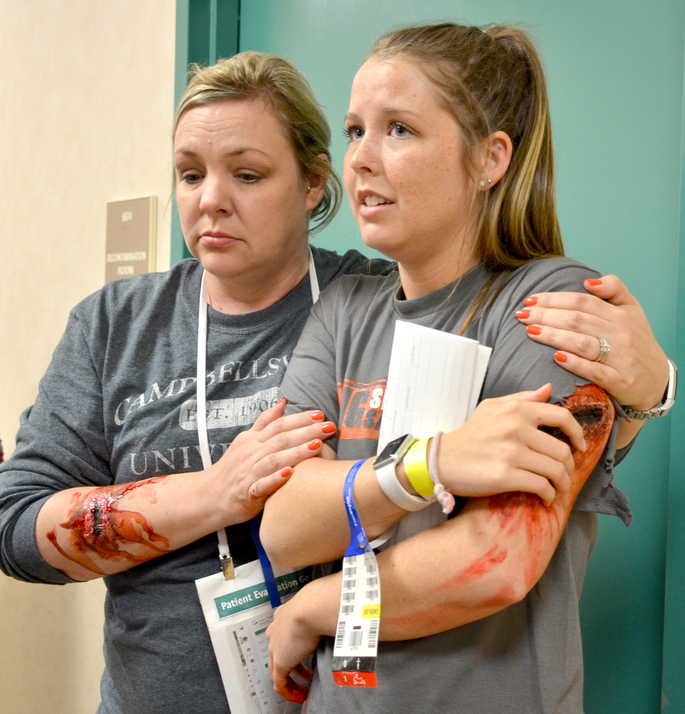 Jennifer Richerson, left, secretary for the School of Nursing, comforts Taylor Elardo, a CU nursing student, as they play shot victims during the active shooter mock scenario held on Campbellsville University’s campus on April 27. (CU Photo by Andrea Burnside)
