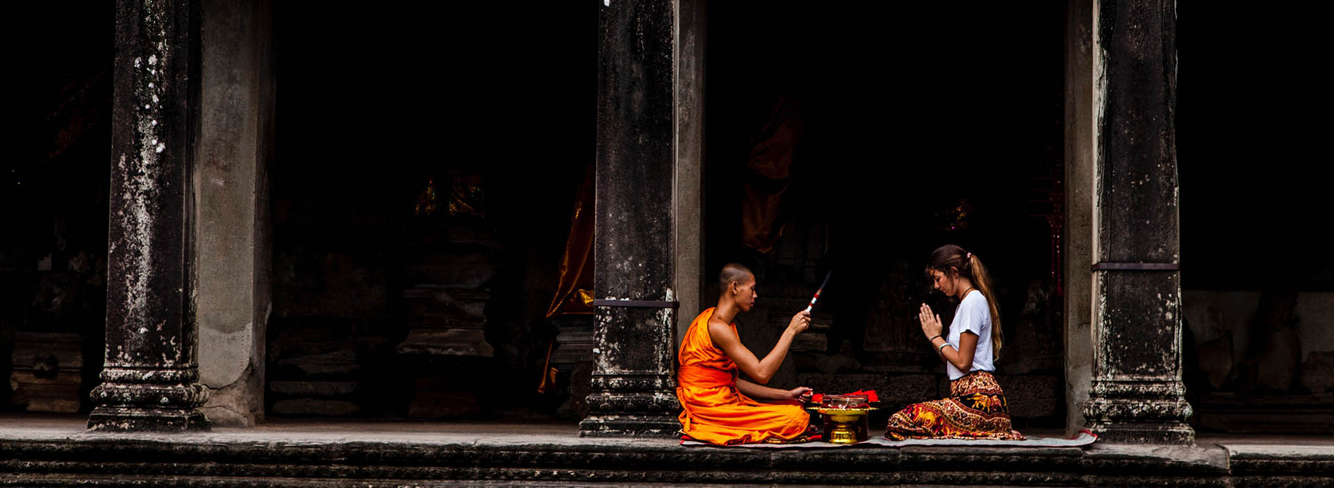 Woman sitting in front of monk