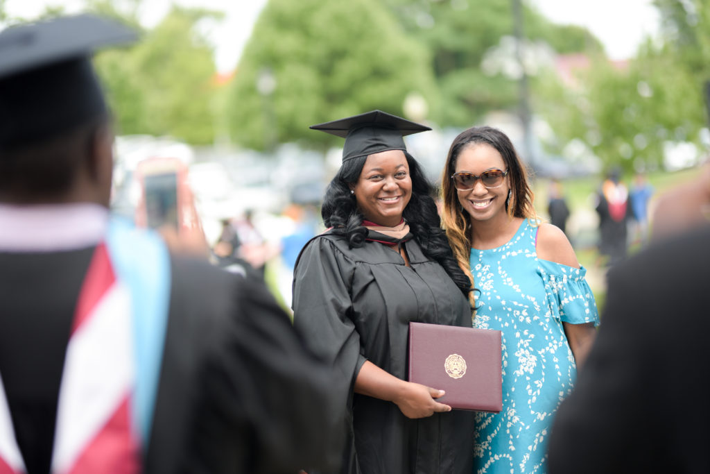 From left, LaKeia Smith of Nicholasville, Ky., takes photos with Sharea Coleman, her cousin, after receiving her diploma from Campbellsville University. (Campbellsville University Photo by Joshua Williams)