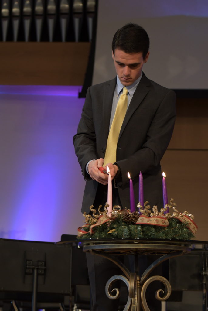 Corbin Harris lights the advent candles during the CU Family chapel service. (CU Photo by Emily Barth) 