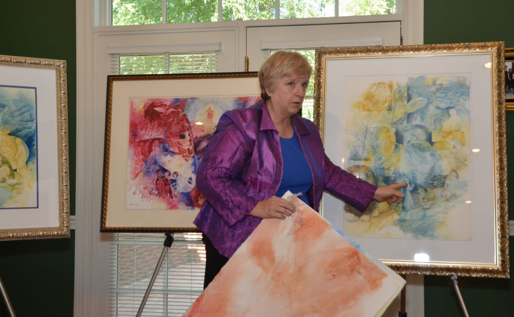 Cora Renfro, an adjunct instructor in art at Campbellsville University, demonstrates how she produces her artwork at a meeting of the Campbellsville University Women’s Alliance. (Campbellsville University Photo by Joan C. McKinney)