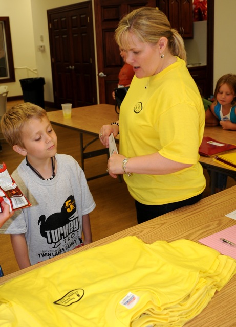 Kids College graduate Bode Copeland asked Director Carol Sullivan, "So, aren' we supposed to have caps and gowns?" After she explained that Kids College grads got yellow t-shirts instead, he asked, "how did you know the right sizes to get?" And after she answered that, Bode had more questions. Thats what Kids College encourages. (CU Photo by Linda Waggener)