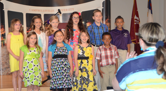 Cyndi Crowder Chadwick, right, directs her 3rd grade Campbellsville Elementary School Choir at  the Excellence in Teaching Awards Ceremony. Students from left are: Front row -- Gracie Crews,  Brianna Davis, Leigh Hicks and Zamar Owens. Back row --  Alexis Wheeler, Brianna Hayes,  Whitney Frazier, Mary Russell, Wesley Reynolds and Ronin Smith. (Campbellsville University  Photo by Linda Waggener)
