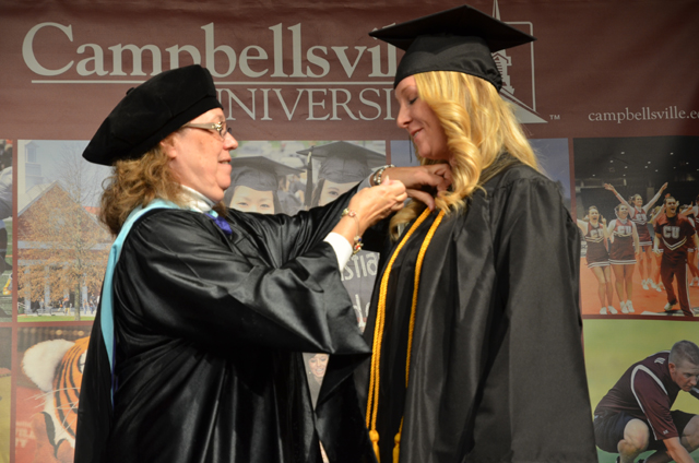 Amanda Carnes, right, receives her education pin at the CU School of Education Pinning Ceremony Dec. 14 in the Russ Mobley Theater from Dr. Sharon Hundley, associate professor of education and chair of the early childhood education program. (Campbellsville University Photo by Joan C.  McKinney)