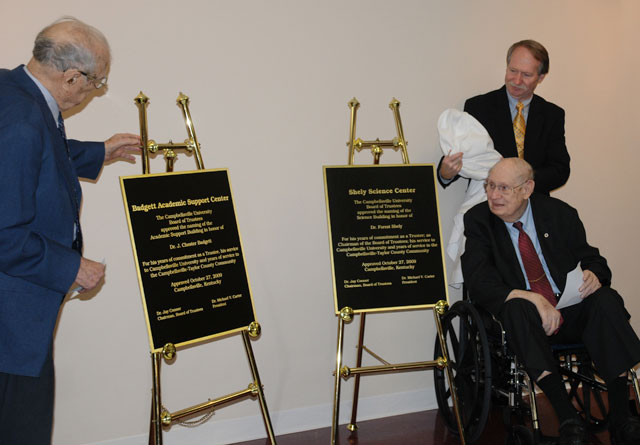 Dr. J. Chester Badgett, left, and Dr. Forest Shely, long-term trustees at CU, unveil the new plaques naming the Badgett Academic Support Center, formerly the Student Union Building, and the Shely Science Center in their honor at the Board of Trustees meeting Oct. 27. Shely's son Bill helps uncover the plaque.