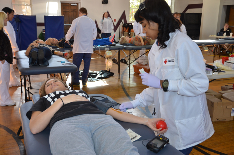 Bethany Gusler, a Campbellsville University senior from Sonora, Ky., donates blood at Campbellsville University Nov. 14. Jasmine Rowan with the American Red Cross prepares to take her blood. The university’s goal was 85 units, and 109 units were collected. The next blood drive on campus is Feb. 20, 2014. (Campbellsville University Photo by Bethany Thomaston)