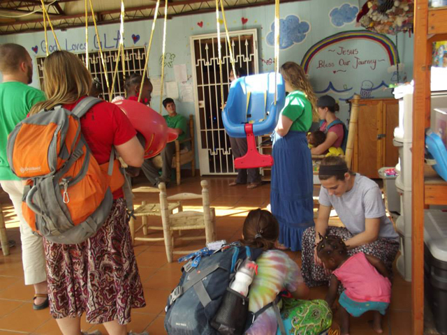 Cortni Cruse, bottom right, at left, and Bethany Thomaston work with children in Haiti.
