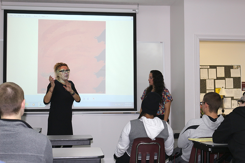 Eva Grande speaks to students about bull fighting in Spain, and how the painting behind her was made in opposition of the sport. Connie Gough, right, translated for her. (Campbellsville University Photo by Drew Tucker)