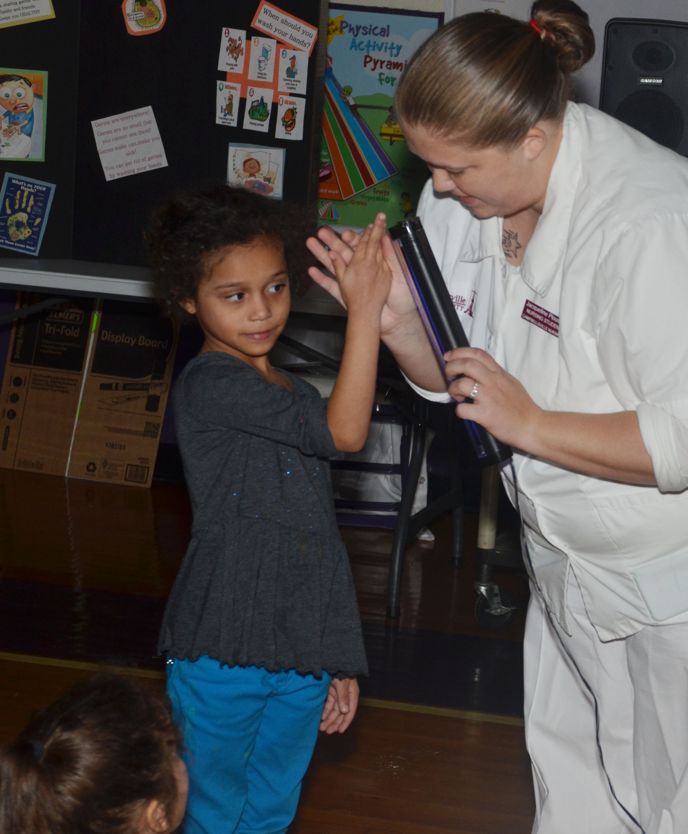 CU nursing student Jackie Plouvier shows how well CES kindergartener Jyra Welch did washing her hands.