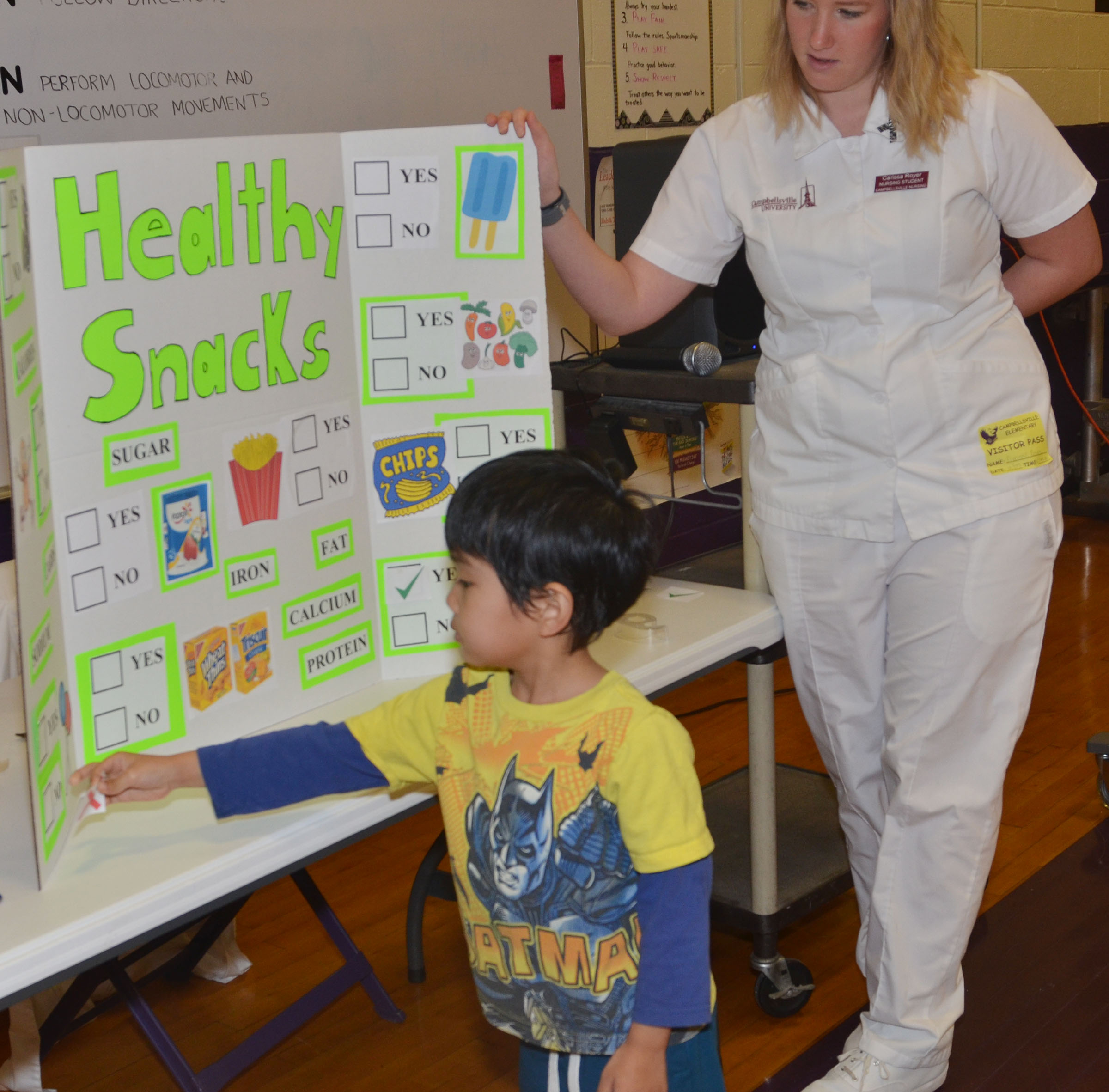 CU nursing student Carissa Royer asks CES kindergartner Zach Hak to choose a not so healthy snack.