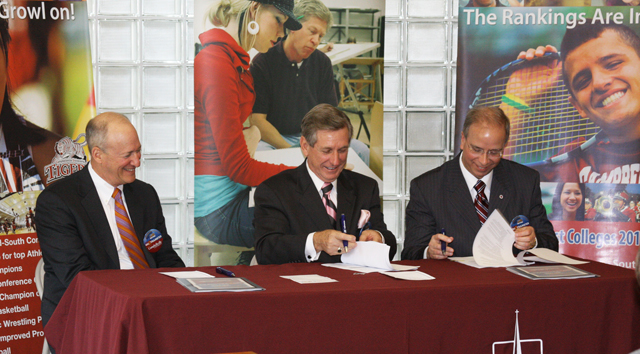  Dr. Michael McCall, center, president of KCTCS, and Dr. Michael V. Carter, right, president of Campbellsville University, sign a multi-program agreement between the two institutions. Dr. Robert King, president of the Council on Postsecondary Education, left, was also present for the signing. (Campbellsville University Photo by Katie Johnson)