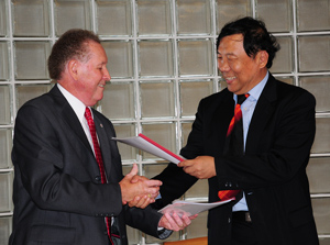 Dr. Frank Cheatham, left, CU vice president for academic affairs, and Du Xiaolin, BUA professor and vice president, exchange agreements. (Campbellsville University  Photo by Christina Kern)