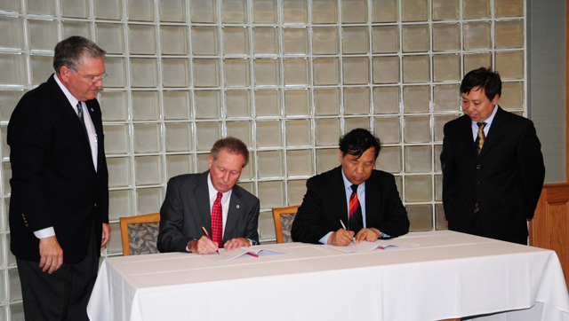 Dr. Frank Cheatham, second from left, and Du Xiaolin, third from left, sign exchange agreements allowing students to study at each others' universities. At far left is Dr. Keith Spears, CU vice president for regional and professional education, and at far right is Zhang Zhiyong, BUA dean of International College, head of International Cooperation Office and professor. (Campbellsville University Photo by Christina Kern)