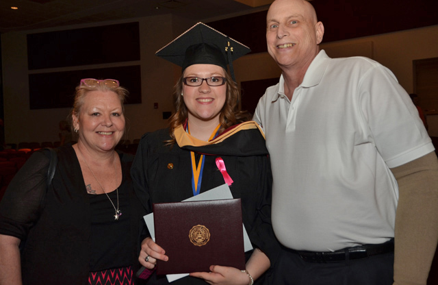 Emily Campbell, center, of Louisville, is congratulated by her mother, Kim, and father, Hugh, after receiving her master of social work degree. 