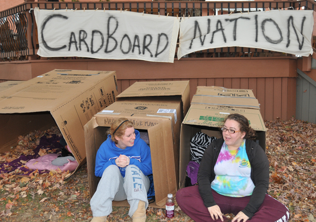 Megan Herrmann, left, a sophomore of Burlington, Ky., and Brittany Maness, a freshman of Campbellsville, Ky., sit in their homes for the evening during Cardboard Nation at Campbellsville University. (Campbellsville University Photo by Ellie McKinley)