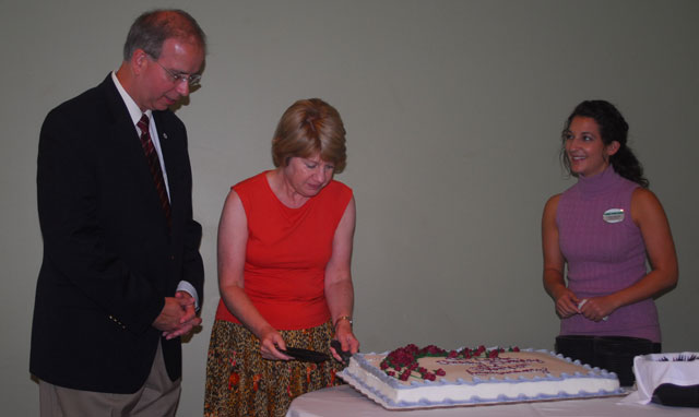 Debbie Carter, first lady of Campbellsville University, cuts her husband's birthday cake at the Board of Trustees luncheon Aug. 11. Dr. Michael V. Carter is 55 years old today. At right is Kelli Fathergill of Pioneer Food Services Inc. (Campbellsville University Photo by Joan C. McKinney)