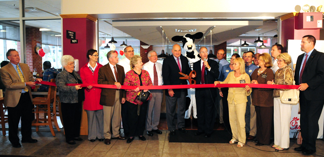 Larry Hayes, center, secretary for the Kentucky Cabinet for Economic Development, cuts the Campbellsville University Chick-fil-A Express along with Dr. Michael V. Carter, CU president, who is speaking. Others participating from left are: Dr. Frank Cheatham, CU vice president for academic affairs; Judy Cox, director, Campbellsville/Taylor County Chamber of Commerce; Terri Cassell, CU Board of Trustees member; Otto Tennant, CU vice president for finance and administration; Campbellsville Mayor Tony Young; Pat Webster, Chamber ambassador; Taylor County Judge/Executive Eddie Rogers; Hayes; Carter; back row -- Chris Flanagan, operator, Chick-fil-A of Elizabethtown, Ky.; Sherri Noland, manager, CU Chick-fil-A Express; John Chowning, CU vice president for church and external relations and executive assistant to the president; Monte Veatch, director, Pioneer College Caterers Inc.; Dan Poset, district supervisor of Pioneer College Caterers Inc.; and Pieter DeGrez, Blevins Construction Co. Front row – Susie Skaggs, past president; Betty Hord and Gladys Montgomery, chamber ambassadors; and Benji Kelly, CU vice president for development and chamber director. (Campbellsville University Photo by Joan C. McKinney)