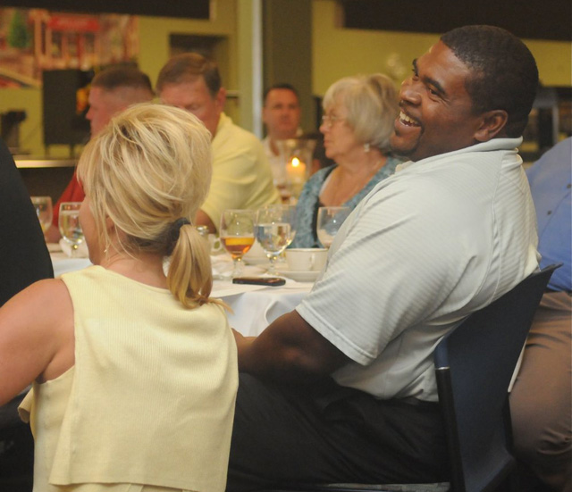 Head football coach Perry Thomas gets a laugh out of something Rhonda Smith tells him as items are being auctioned at the Annual CU Booster Dinner and Auction. (CU photo by Richard RoBards)