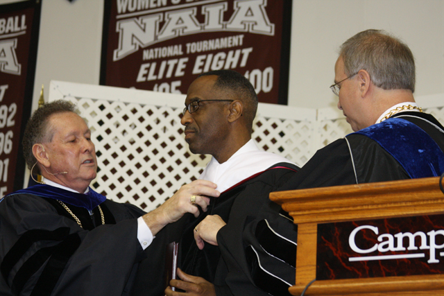  Dr. Frank Cheatham, left, vice president for academic affairs, and Dr. Michael V. Carter, right, president of CU, place the honorary doctorate hood on Dr. Kevin Cosby, undergraduate commencement speaker and president of Simmons College of Kentucky. (Campbellsville University Photo by Katie Johnson)