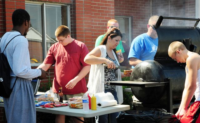 Campbellsville University freshman Coty Eames, far left (who introduced himself as Gorge Foreman), was one of many new students stopping by the grilling operation at North Hall to enjoy some of the hamburgers and hotdogs served by the Mt. Roberts Baptist Church. Grilling are Samantha Farmer and  Steven Thomas, assisted by members of the Mt. Roberts youth group. (Campbellsville University Photo by Linda Waggener)