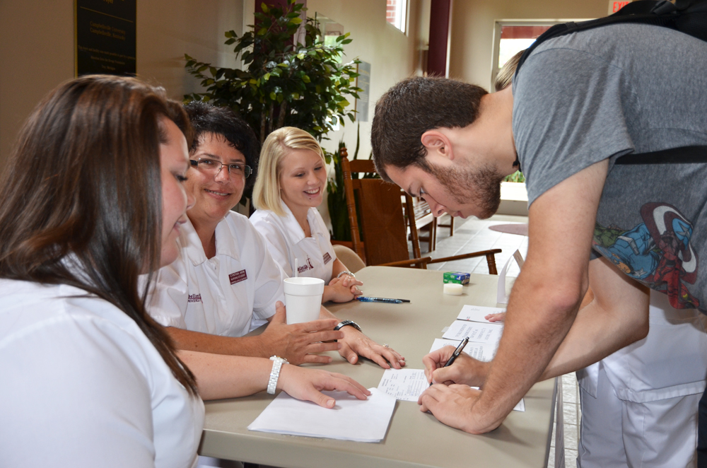 Michael Jennings signs up to have his blood donated to the American Red Cross. Student nurses Tonya Kessler, Cindy Akin and Carla Allen Mattingly, set up their booth in Winters Digning Hall during lunch hour to attract the most signatures. (Campbellsville University Photo by Ye Wei "Vicky")