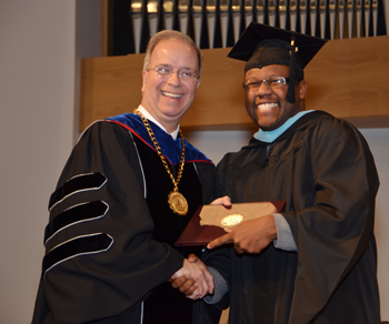 DeMarcus Compton, right, of Campbellsville receives his master of arts in special education degree from Dr.  Michael V. Carter, president. (Campbellsville University Photo by Christina Kern)