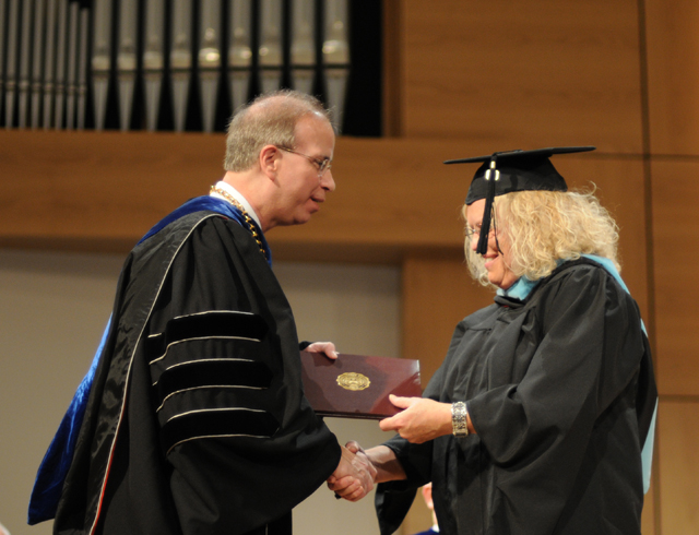 Debra Dean, right, receives her diploma from Dr. Michael V. Carter, president of Campbellsville University, after having broken down in her car on the way to commencement. (Campbellsville University Photo by Ashley Zsedenyi)