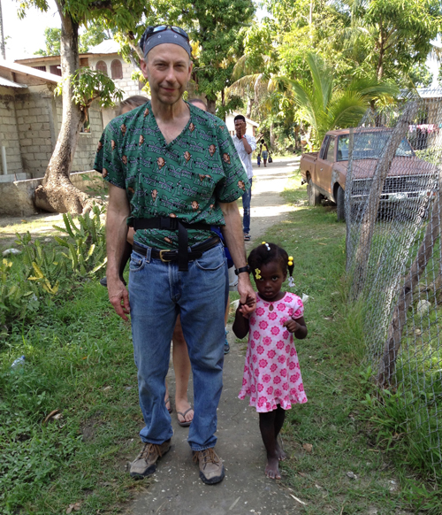 Dr. Marc Workman, a physician with Louisa Medical Clinic in Louisa, Ky.,  walks with a young child in Neply, Haiti during his mission trip.