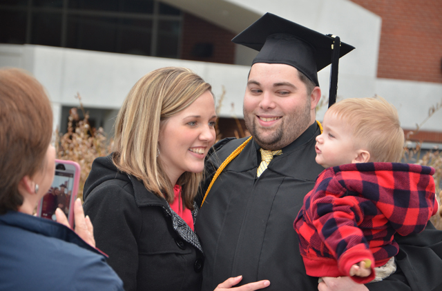 Dustin Barnes, center, has his picture taken by his mother-in-law Pam Weatherford, following his commencement. His wife, Janet, a 2008 CU graduate, is at left with his son Jackson at right.  (Campbellsville University Photo by Rachel DeCoursey)