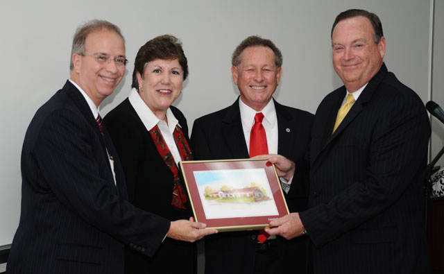 Dr. Phil Rogers, far right, executive director, Education Professional Standards Board, receives a framed picture of the Campbellsville University School of Education building to be hung in the conference room where EPSB meetings are held in Frankfort, from Dr. Brenda Priddy, dean of the School of Education. At left is Dr. Michael V. Carter, president of CU, and Dr. Frank Cheatham, vice president for academic affairs at CU. (Campbellsville University Photo by Andre Tomaz)