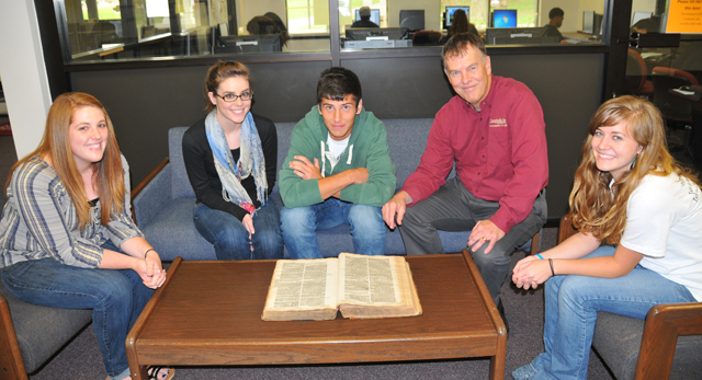 A group of students meet with Dr. Glen Taul, CU archivist, to look over a Bible in the display at the Montgomery Library. From left are: Natalie Buckley, Louisville; Ashley Bolton, Glendale, Ky.; Austin Collviver, Mt. Sterling, Ky.; Taul; and Chelsi Netherland of Leitchfield, Ky. (Campbellsville University Photo by Nicholas Osaigbovo)