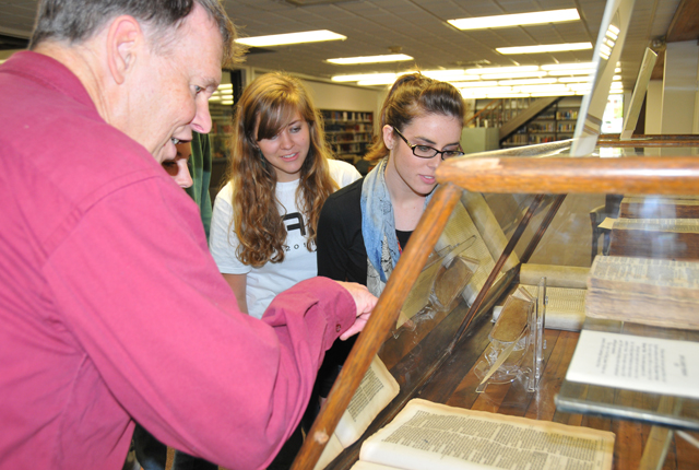 Dr. Glen Taul, Campbellsville University archivist, shows the exhibit of Bibles from 1247 to 1612, to Chelsi Netherland, left, of Leitchfield, Ky., and Ashley Bolton of Glendale, Ky. (Campbellsville University Photo by Nicholas Osaigbovo)
