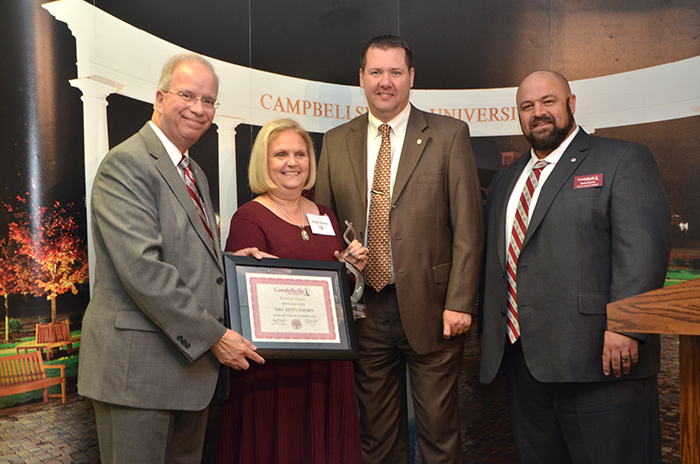 Lindy Forbes, second from left, was named Campbellsville University’s 2016 Distinguished Alumna at the Homecoming Reception Oct. 14. Making the presentation was from left: Dr. Michael V. Carter, president; Benji Kelly, vice president for development, and Darryl Peavler, director of alumni relations. (CU Photo by Joan C. McKinney)
