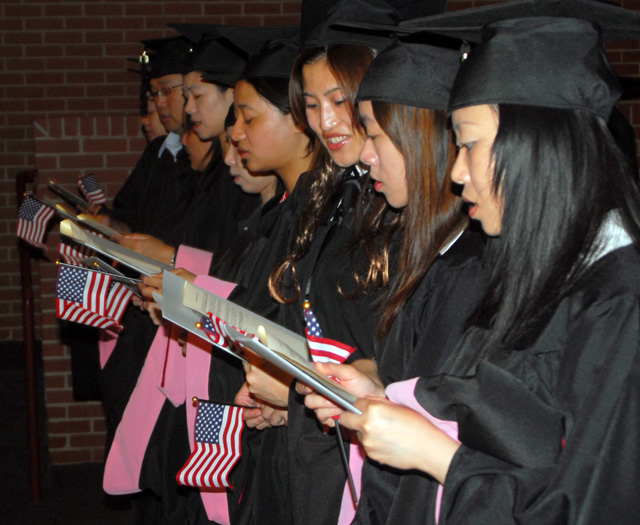 The graduates hold American flags while singing a hymn during the commencement ceremony. (Campbellsville University Photo by Joan C. McKinney)