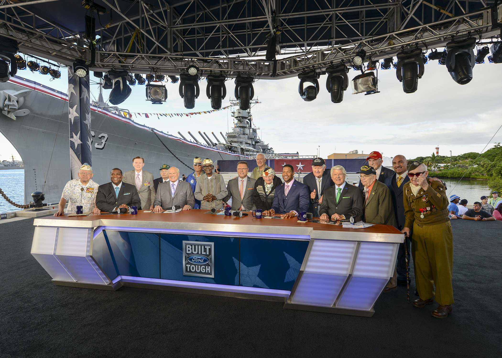 Dr. E. Bruce Heilman, back row on the right in the red hat, the hosts of FOX NFL Sunday Live, service members and Pearl Harbor survivors pose for a photo during FOX NFL Sunday Live Special