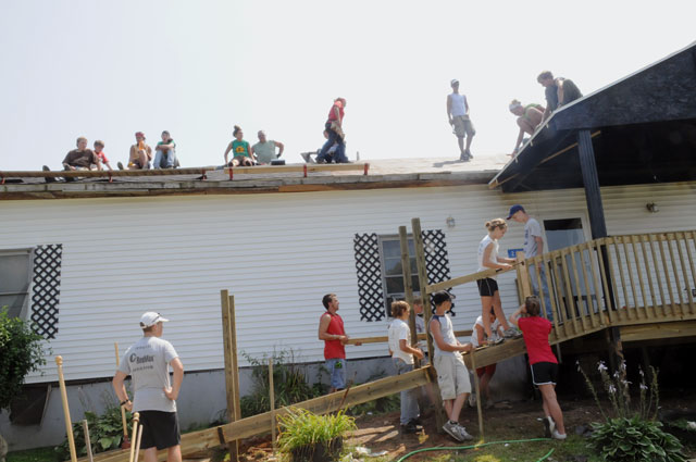 A group of volunteers from Brainerd United Methodist Church in Chattanooga, Tenn., Lynn Haven United Methodist Church in Panama City, Fla., First United Methodist Church in Panama City and Mt. Vernon Baptist Church in Boone, N.C., under the direction of Kentucky Heartland Outreach interns Lindsay Jones, Collin Johnson and Amanda Mosier, build a deck and ramp and replace a roof on a home near Cave City, Ky., during a week-long summer camp with KHO. (Campbellsville University Photo by Ashley Zsedenyi)