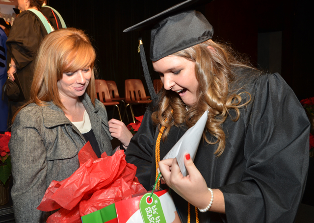  Karlie Neal, right, who spoke at the School of Education pinning before commencement, opens a  gift from McLane Farr. Neal received a bachelor of science degree in elementary education/P-5.  (Campbellsville University Photo by Joan C. McKinney)