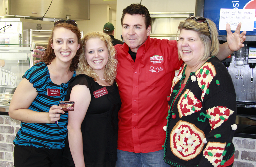 Kellie Vaughn and Kristin Davis, from left, and Pam Tennant, who was wearing a pizza sweater and pizza earrings, have their photo taken with "Papa" John Schnatter. (Campbellsville University Photo by Rachel DeCoursey)