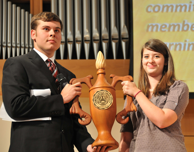 Michael Jennings, left, a sophomore at Campbellsville University from Edmonton, Ky., passes the Lamp of Learning on to the Class of 2016, represented by McKenzie Young, a freshman from Russellville, Ky. (Campbellsville University Photo by Christina L. Kern)