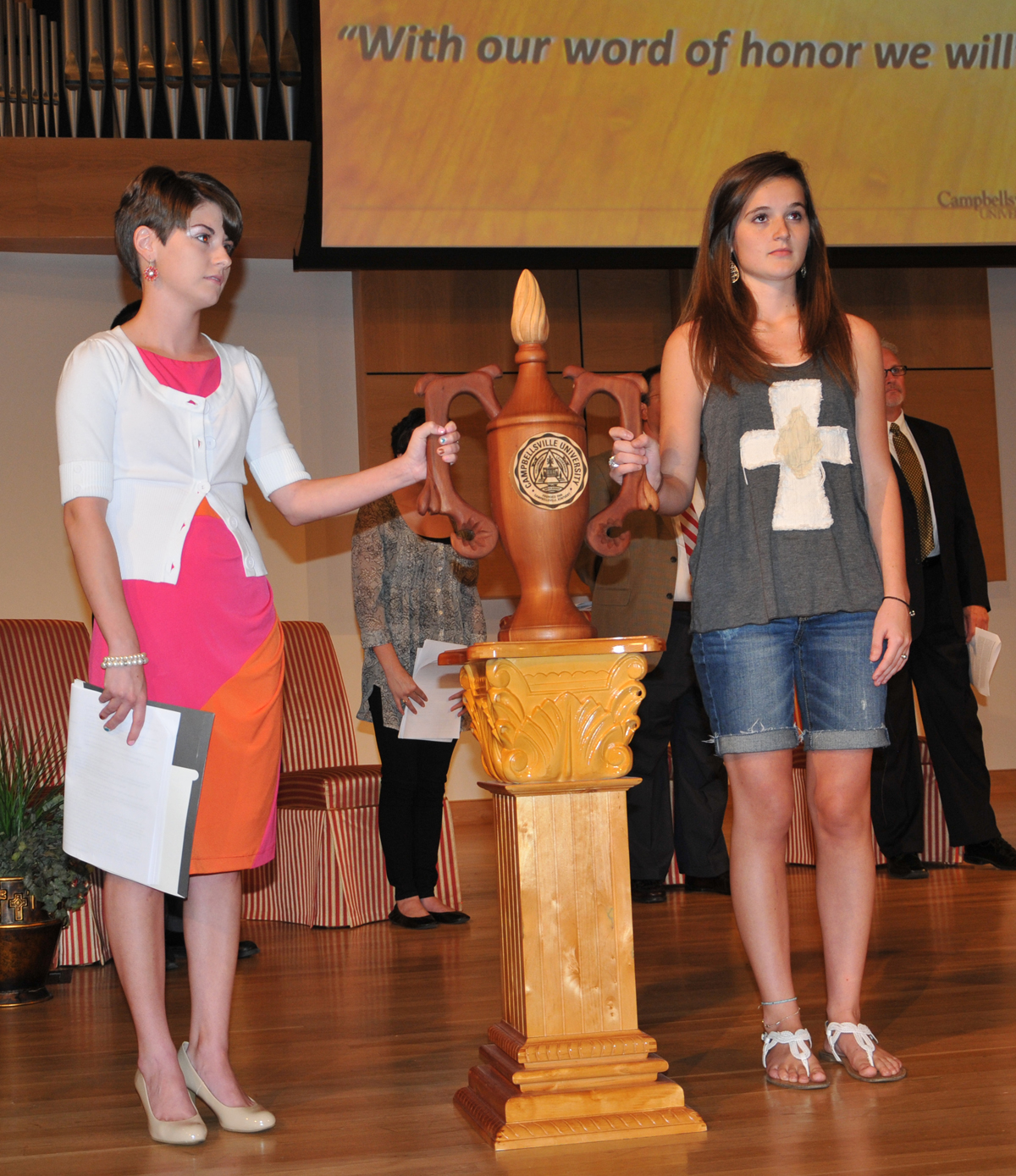 The Lamp of Learning was passed from Jacqueline Nelson to Abby Harnack, freshman president’s scholar from Bowling Green, Ky. (Campbellsville University photo by Linda Waggener)