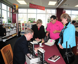 U.S. Sen. Mitch McConnell signs a book for Linda Hatter, superintendent of the Casey County School System, as John Burch, CU librarian, waits his turn. LeAnn Crosby, McConnell's field representative, is in the center. At top right, employees with the CU Barnes & Noble College Bookstore pose with McConnell. From left are: Donna Wright, manager; Rebecca Newton; McConnell and Ashley Kirtley, assistant manager. (Campbellsville University Photos by Joan C. McKinney)