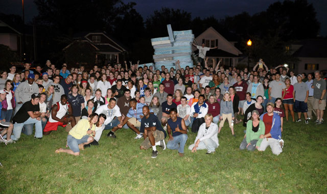 Campbellsville University students gathered in front of their record-breaking stack of mattresses with Andrew Ward, director of student activities and intramurals and coordinator of the event, standing on the ladder in back. (Campbellsville University Photo by André Tomaz)