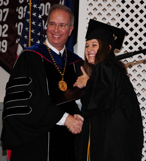 Morghan Elizabeth Lanham Alway gives a  thumbs up as she receives her diploma from Dr. Michael V. Carter, president. Alway, of  Elizabethtown, Ky., received a bachelor of  arts in music and English. (Campbellsville University Photo by Ashley Wilson)