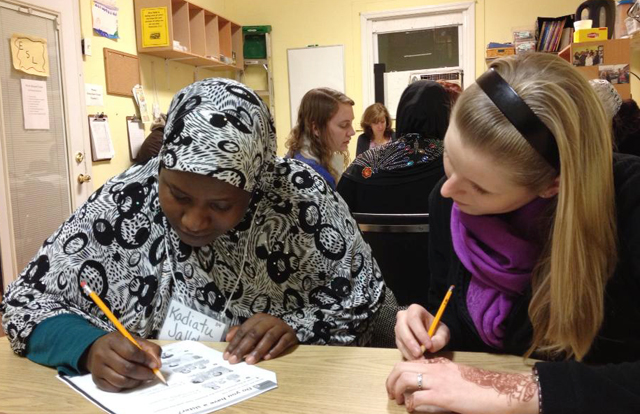 Sarah Haven, right, a senior of Shelbyville, Ky., helps a student with an English assignment in New York. The team also presented the gospel through a Henna ministry, offering temporary tattoos, a traditional sign of beauty in Middle Eastern countries and can hold a variety of meanings based on its design and ink.