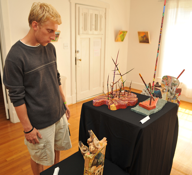 Phil Carlisle, a senior from Campbellsville, looks at some of the artwork of Lynn and Claude  Robertson on display in the Art Gallery at Campbellsville University. (Campbellsville University Photo by Bayarmagnai "Max" Nergui)