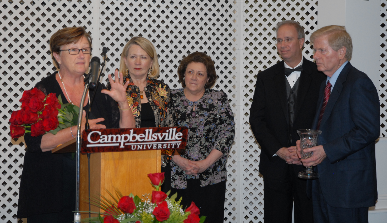 Betty Porter of Mt. Washington, Ky. thanks the Campbellsville University Advancement Board for the presentation of the Derby Rose Gala Award to her and her husband, Dr. J. Chester Porter, far right. Gwinn Hahn, second from left, is chair of the Derby Rose Gala and Sara Curry, beside her, is chair of the Advancement Board. Campbellsville University president Michael V. Carter is beside Porter. (Campbellsville University Photo by Joan C. McKinney)