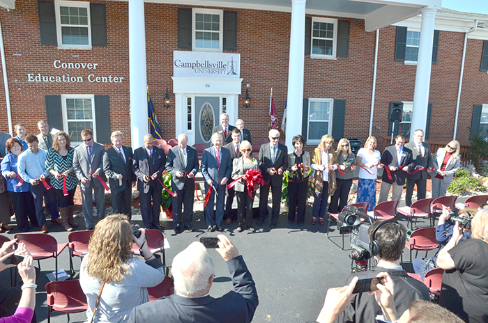 United States Sen. Mitch McConnell (R-Ky.), center, helps cut the ribbon for the dedication of the Conover Education Center. Members of the Harrodsburg Chamber and the community helped with the ribbon cutting. (Campbellsville University Photo by Joshua Williams)