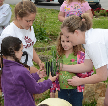 Campbellsville University students Caroline Owen, left, and Jackie Schwieger work with Sarah Atkins, left, and Haley Kelly of Campbellsville Elementary School, as they begin planting flowers at the Log Cabin Park. (Campbellsville University Photo by  Joan C. McKinney)