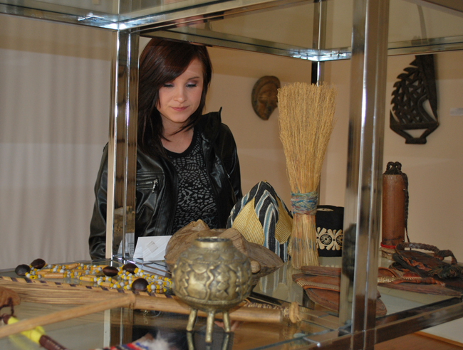 Skye Gardner, a senior at Campbellsville University, looks over the Henderson African artifact collection at the Campbellsville University, looks over the exhibit in the Art Gallery. The exhibit runs through March 26 with a reception March 25. (Campbellsville University Photo by Munkh-Amgalan Galsanjamts)